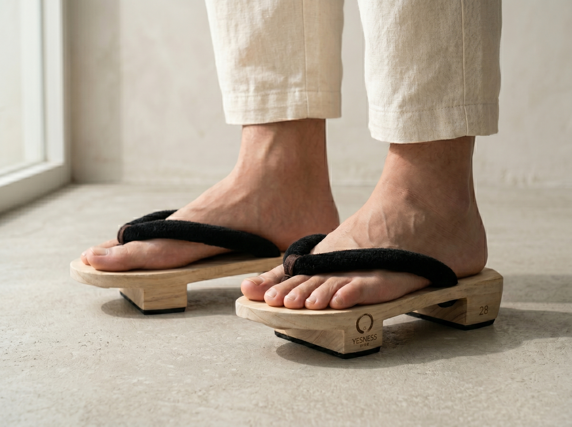 On-foot view of YESNESS geta worn barefoot with linen trousers