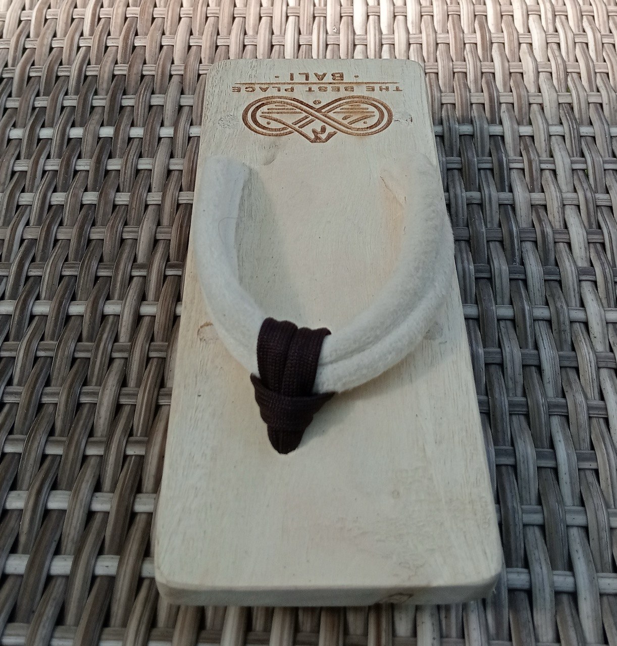 Top-down view of the geta sandal showing the engraved The Best Place Bali emblem